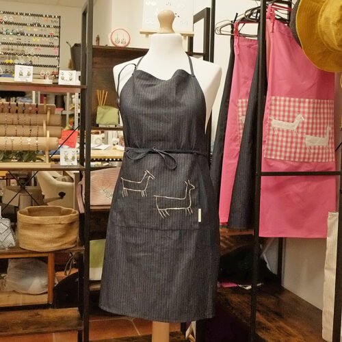 Delantal denim con un bordado inspirado en el petroglifo de A Pedra das Cabras de Riveira