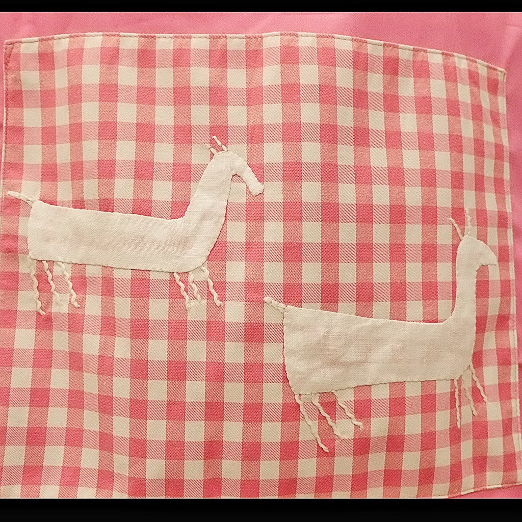 Cabras de 'A pedra das cabras' de lino blanco sobre fondo de cuadros rosa y blanco